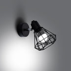 Applique Artemis noir allumée, ombres géométriques de la cage
