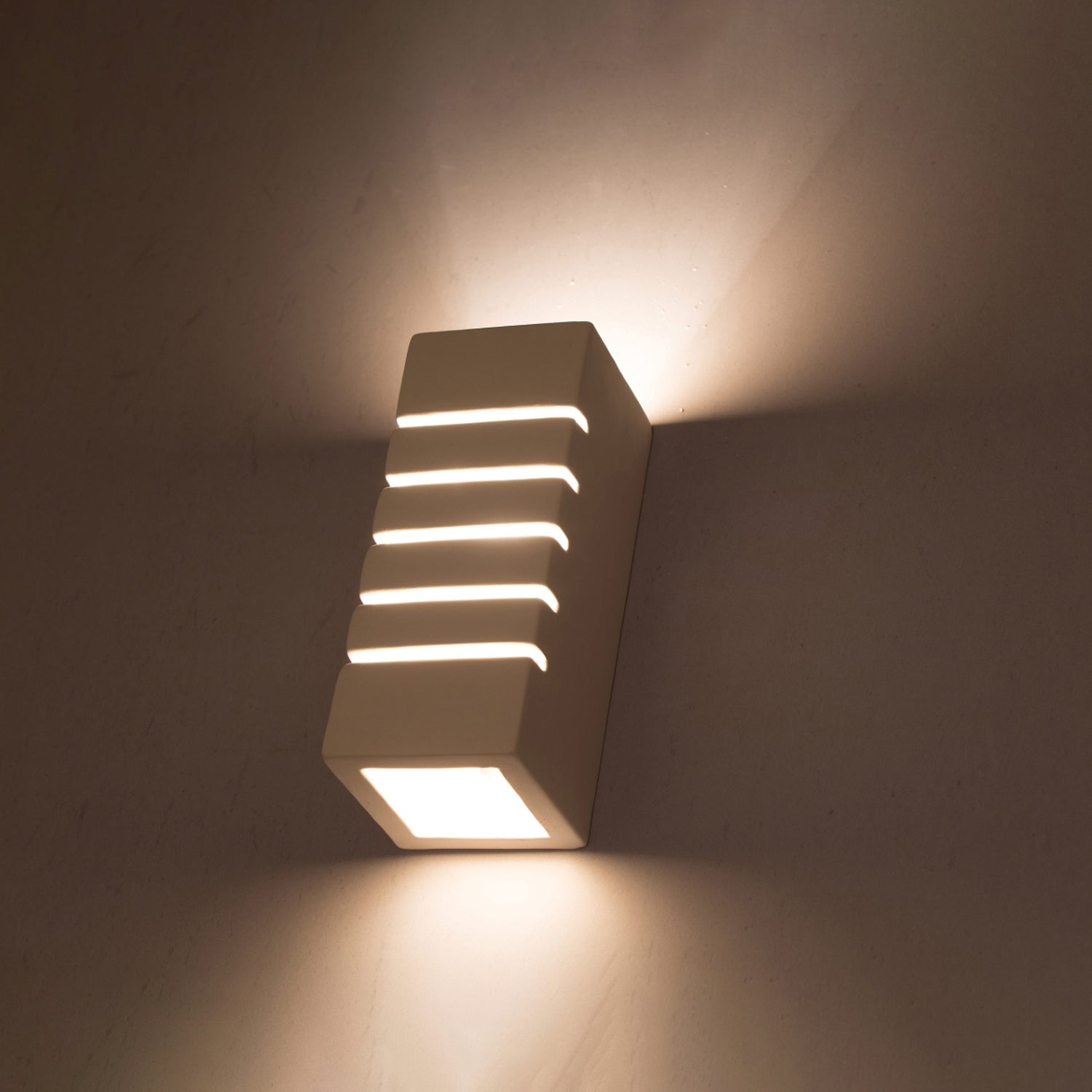 Applique Samir allumée, lignes de lumière par les fentes