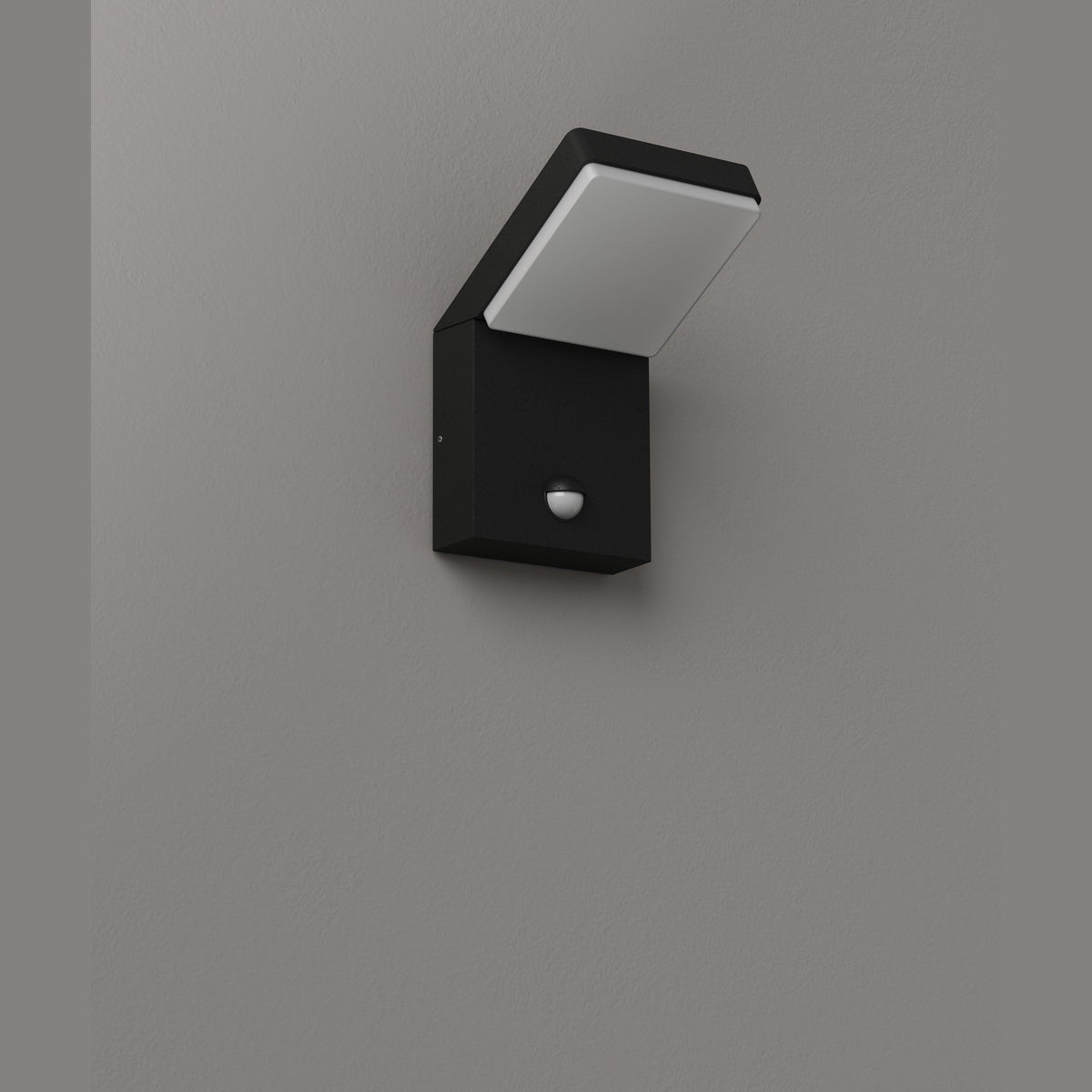 Applique extérieure Fiss éteinte sur un mur gris tête inclinée au-dessus d'un boîtier noir à détecteur