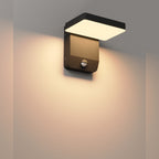 Applique Ladis allumée sur un mur clair lumière chaude diffusée vers le bas