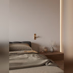 Chambre avec applique liseuse Libra teinte laiton vieilli au mur entre le lit et la table de chevet