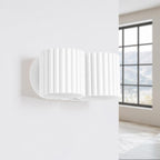 Applique murale Aura 2 en laque blanche éteinte sur un mur clair