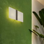 Applique Azalia allumée sur un mur vert avec un halo autour de la plaque