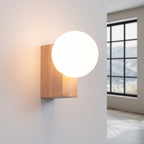 Applique Bulbo allumée diffusant une lumière douce à travers son globe opale