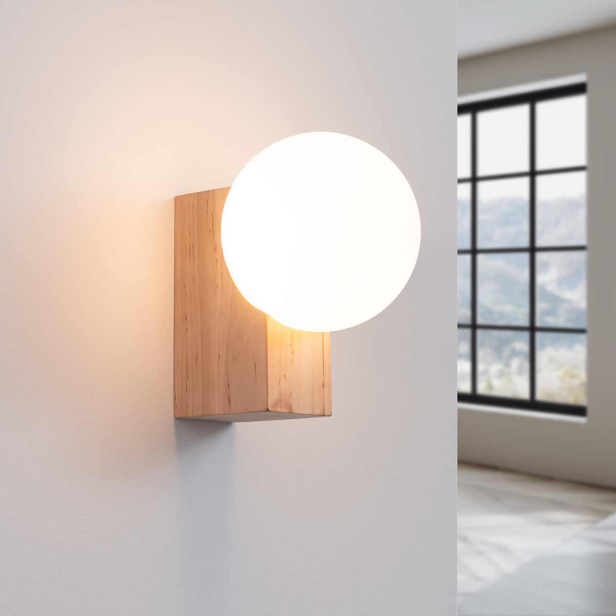 Applique Bulbo allumée diffusant une lumière douce à travers son globe opale