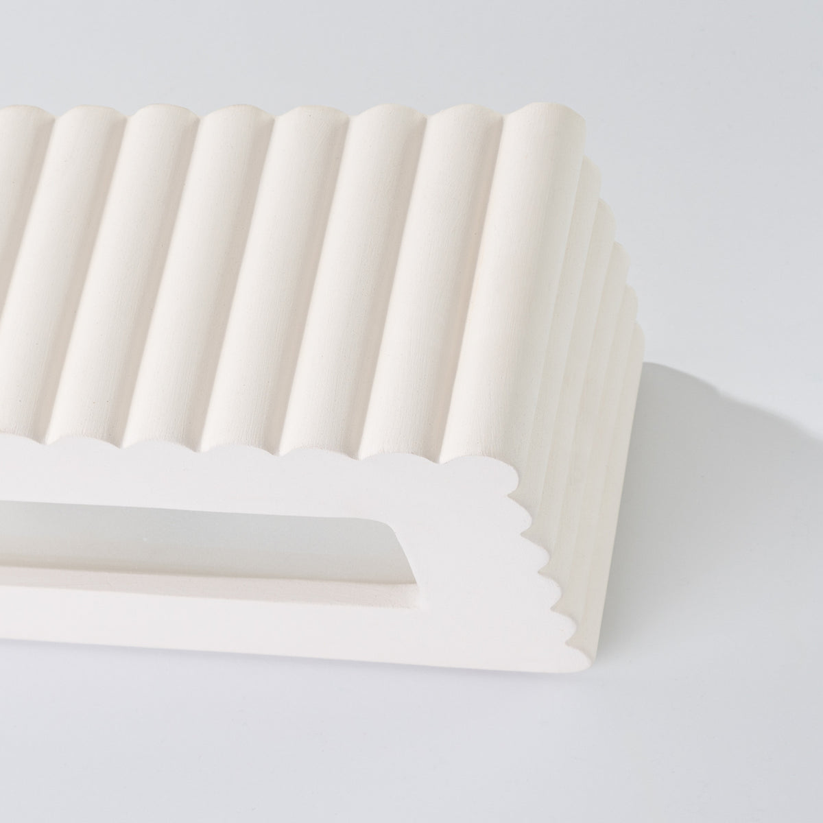 Angle de l'applique Rigata en céramique blanche avec le panneau diffusant de sa fente basse