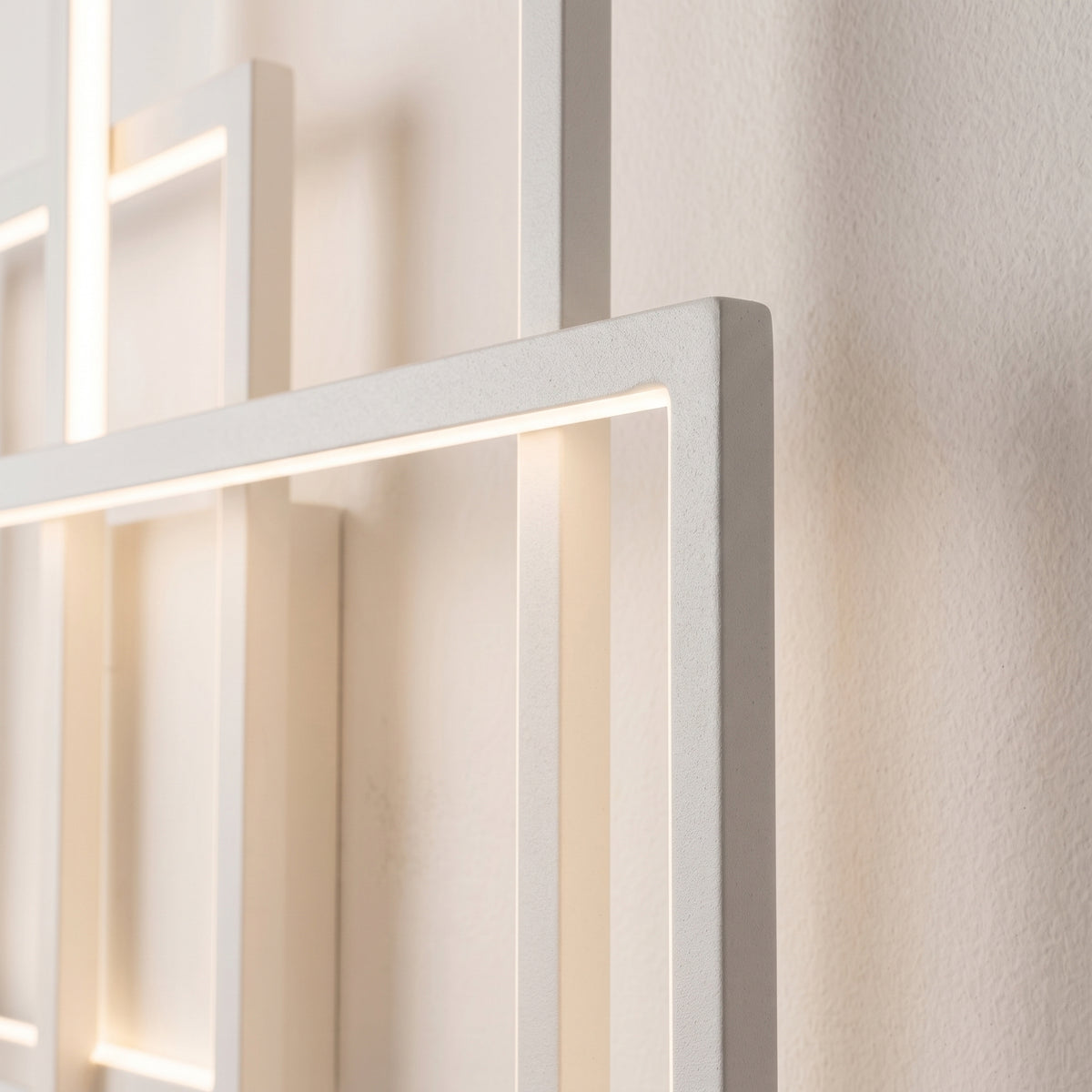 Détail des cadres en métal blanc de l'applique Geometric et de leur bande LED allumée