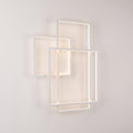Applique murale Geometric LED en métal blanc allumée, trois cadres rectangulaires superposés posés à la verticale sur un mur clair