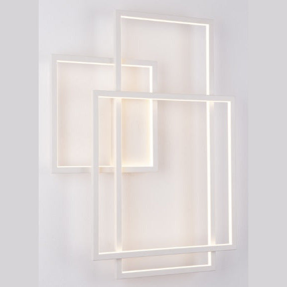 Applique Geometric blanche allumée sur un mur clair les arêtes intérieures des cadres diffusent une lumière chaude
