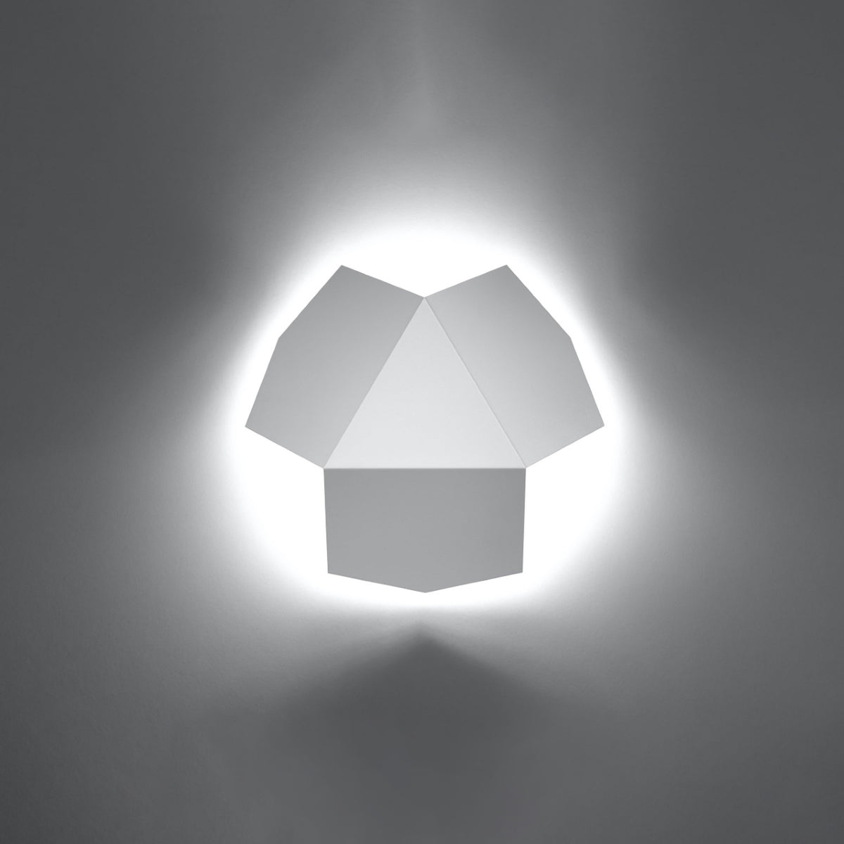Applique Tre en métal blanc allumée avec un halo de lumière autour de ses pentagones