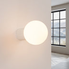 Applique murale Halo boule opale beige allumée, lumière diffuse