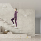 Appliques Helios blanches sur le mur d'un escalier suspendu avec une personne qui monte les marches