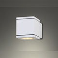 Applique murale Home Square cube d'aluminium blanc allumée qui éclaire vers le bas sur un mur gris