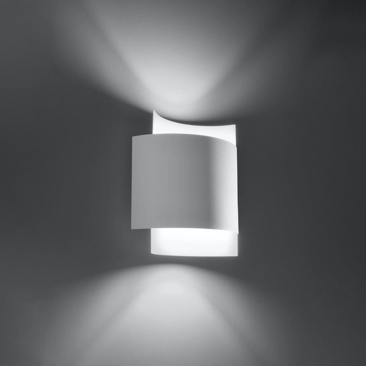 Applique Impact métal blanc allumée vue de trois quarts sur un mur gris