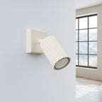 Applique murale Karbon spot cannelé beige posée sur un mur clair, spot orienté vers le bas