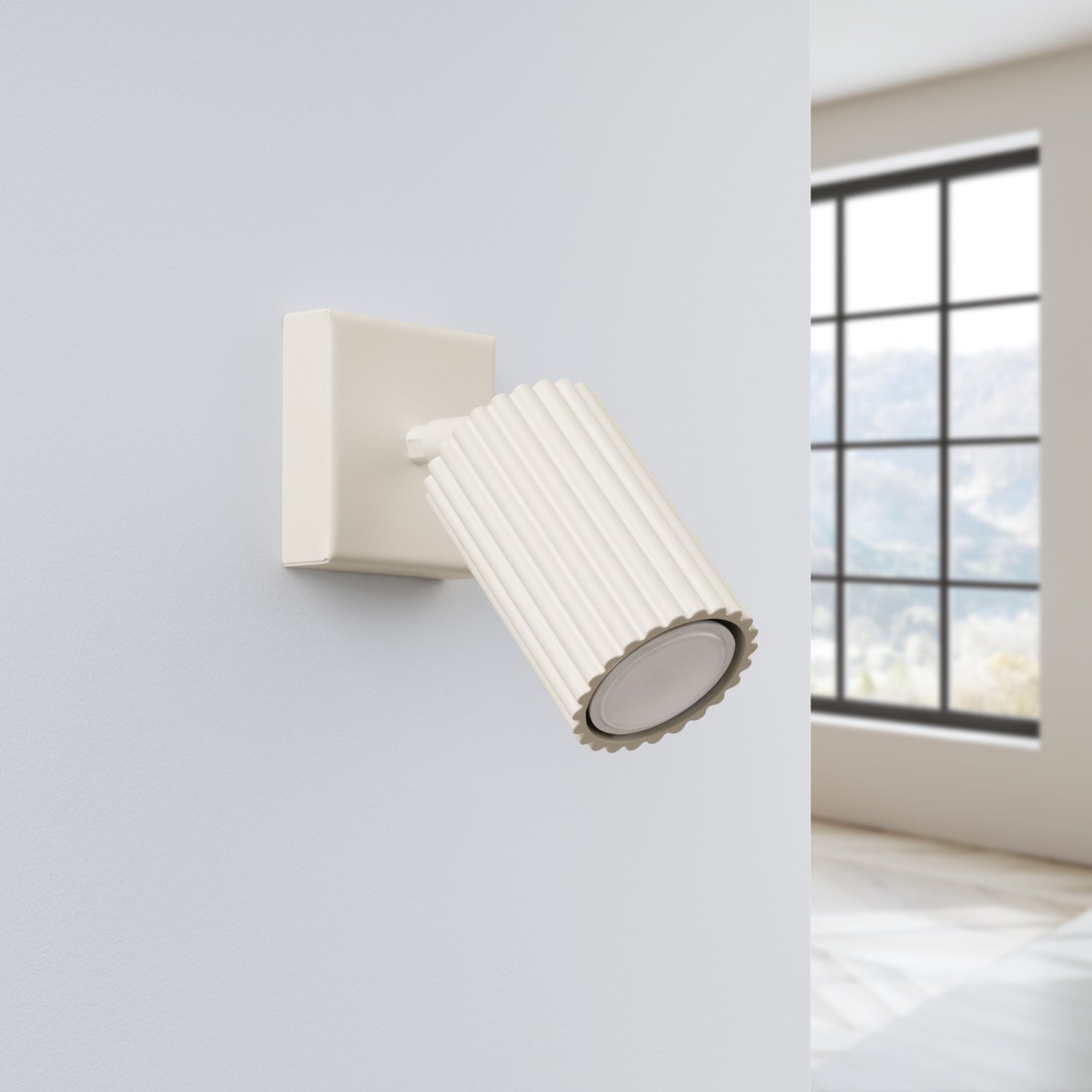 Applique murale Karbon spot cannelé beige posée sur un mur clair, spot orienté vers le bas