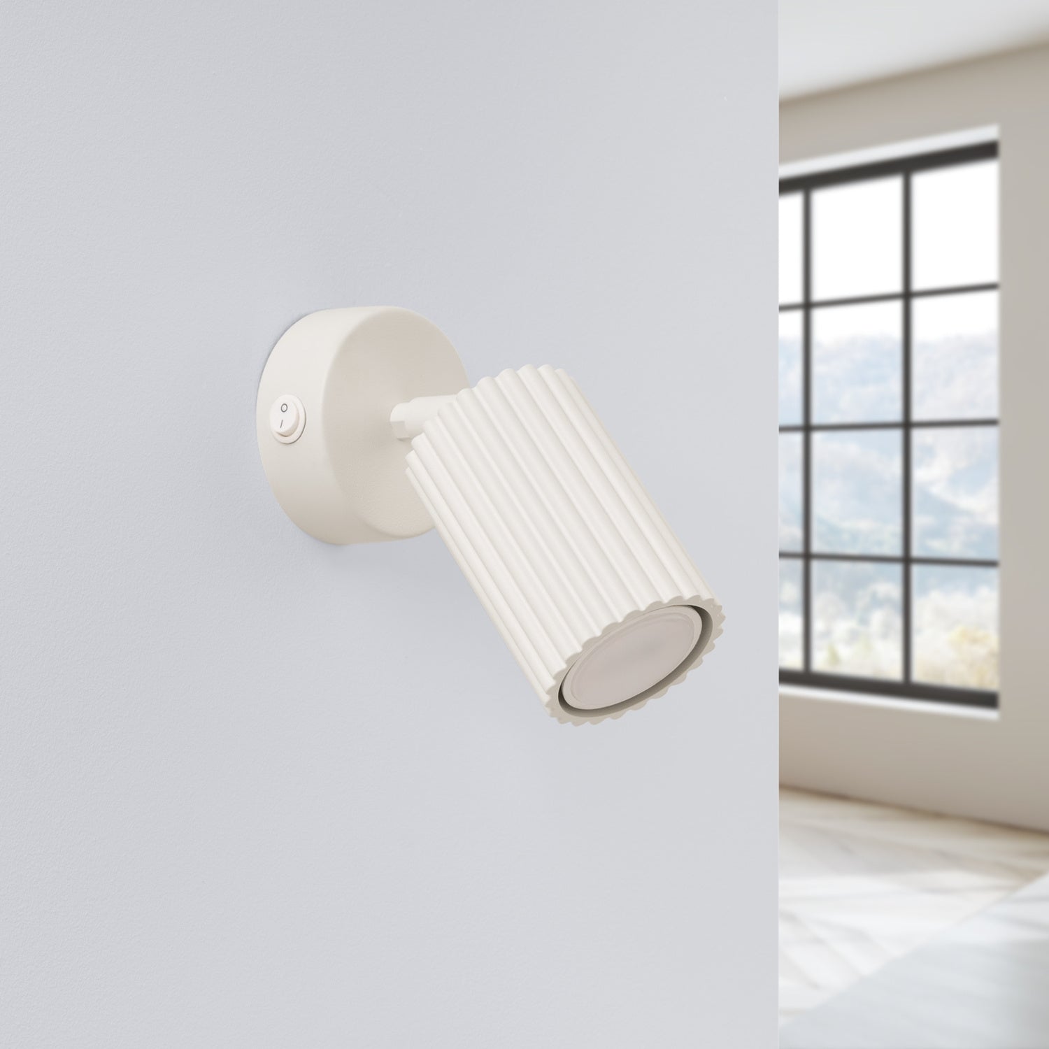 Applique murale Karbon spot interrupteur beige posée sur un mur clair
