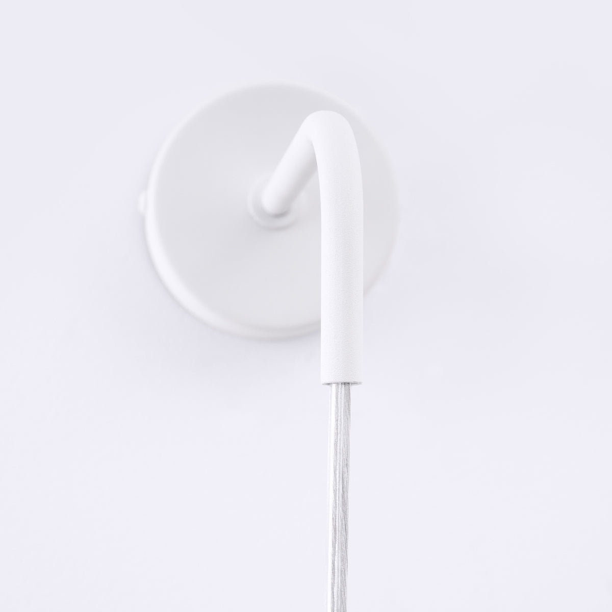 Détail de la platine ronde et du bras coudé de l'applique Lami en acier blanc