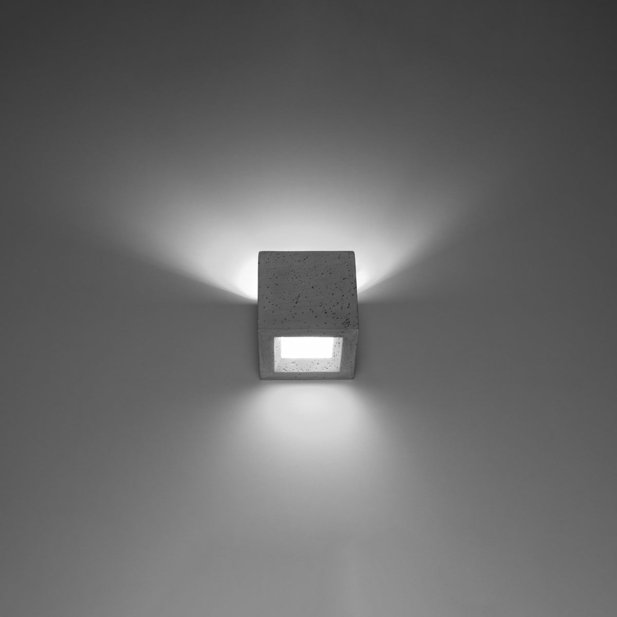 Applique murale Leo en béton gris allumée projetant un halo vers le haut et un halo vers le bas