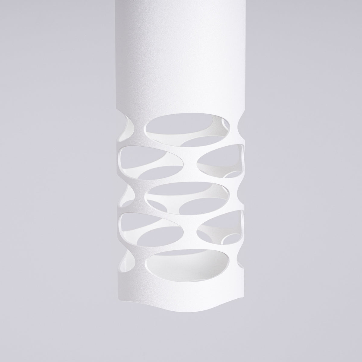 Gros plan de la maille d'ovales découpée dans le tube en acier blanc de l'applique Liro