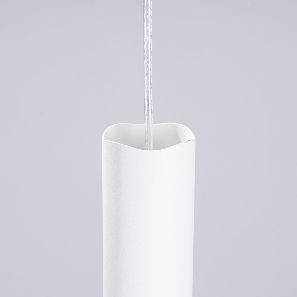 Haut ondulé du tube en acier blanc de l'applique Liro traversé par le câble transparent