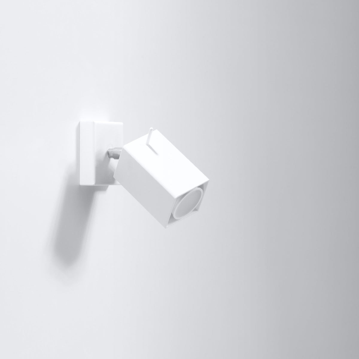 Applique Merida métal blanc fixée sur un mur clair tête inclinée