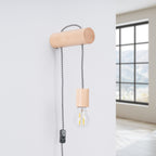 Applique Nimbi fixée sur un mur blanc avec son cordon qui descend vers une prise
