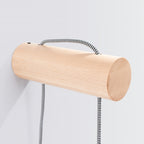 Support cylindrique en hêtre de l'applique Nimbi traversé par le câble tressé noir et blanc
