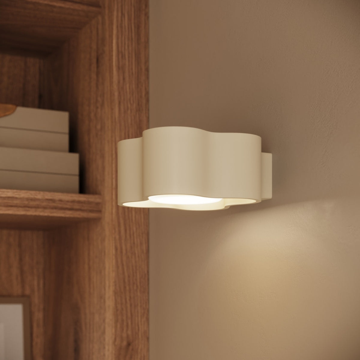 Applique Ovio laque beige allumée sur un mur à côté d’une étagère en bois