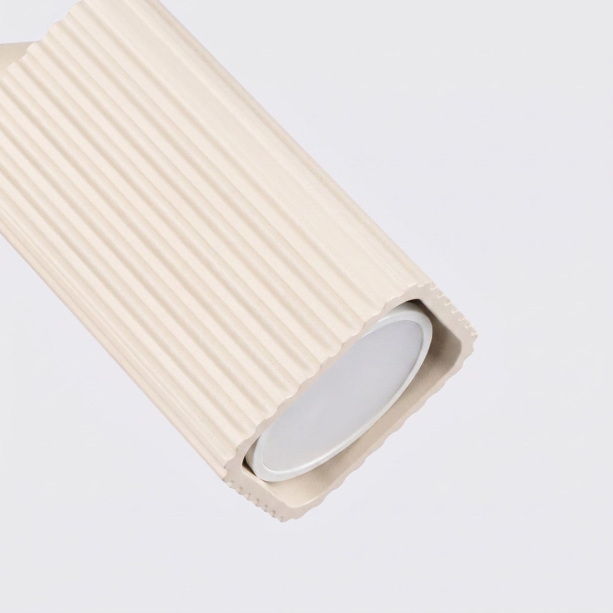 Détail des cannelures et de l'ouverture du spot de l'applique Rayo laque beige