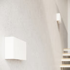 Applique murale Copertura en acier blanc vue de biais sur un mur minéral au-dessus d'un escalier
