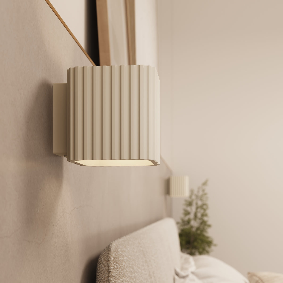 Applique murale Riff laque beige allumée au-dessus d'une tête de lit