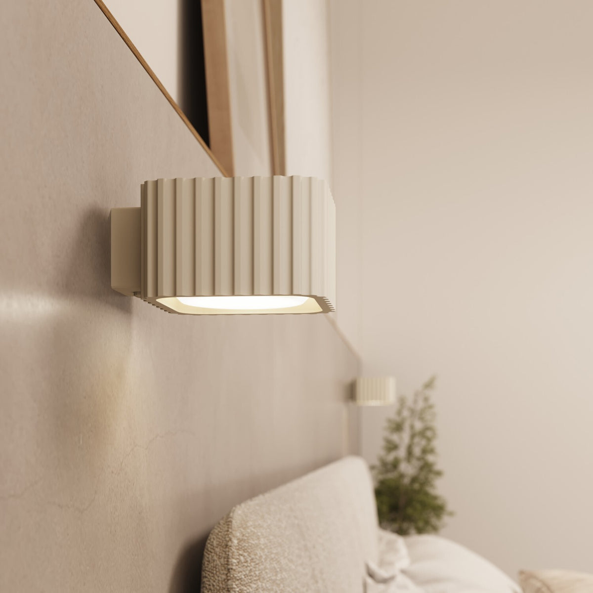 Applique murale Riff laque beige allumée au-dessus d'une tête de lit