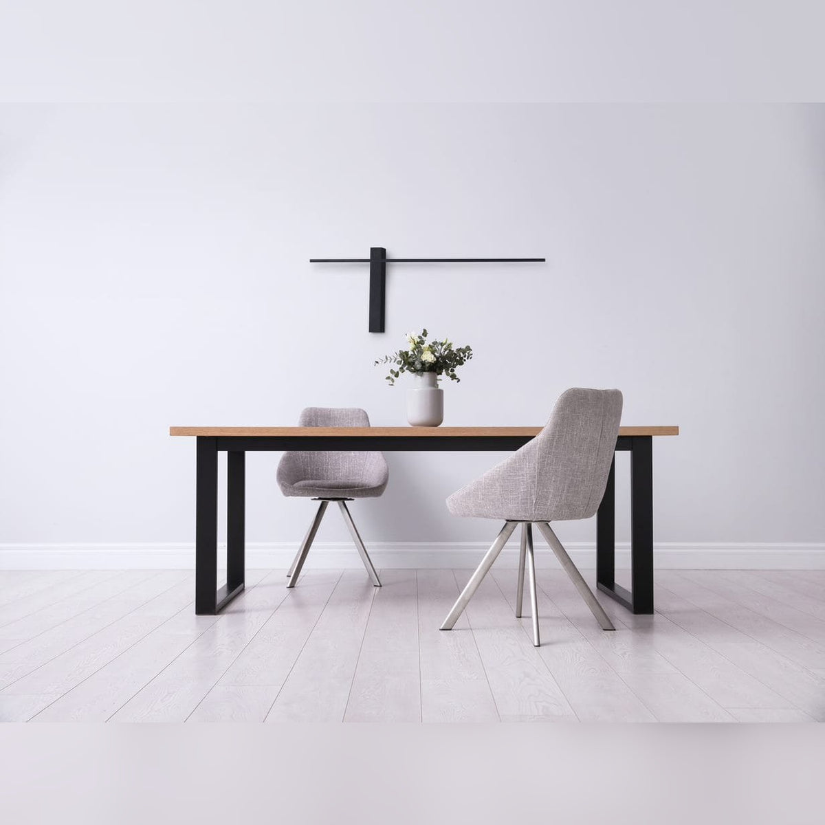 Applique murale Sabre 61 cm noire posée à l'horizontale au-dessus d'une table de salle à manger en bois