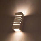 Applique murale Samir allumée en lumière chaude avec lignes de lumière par les fentes et halo vers le haut et le bas