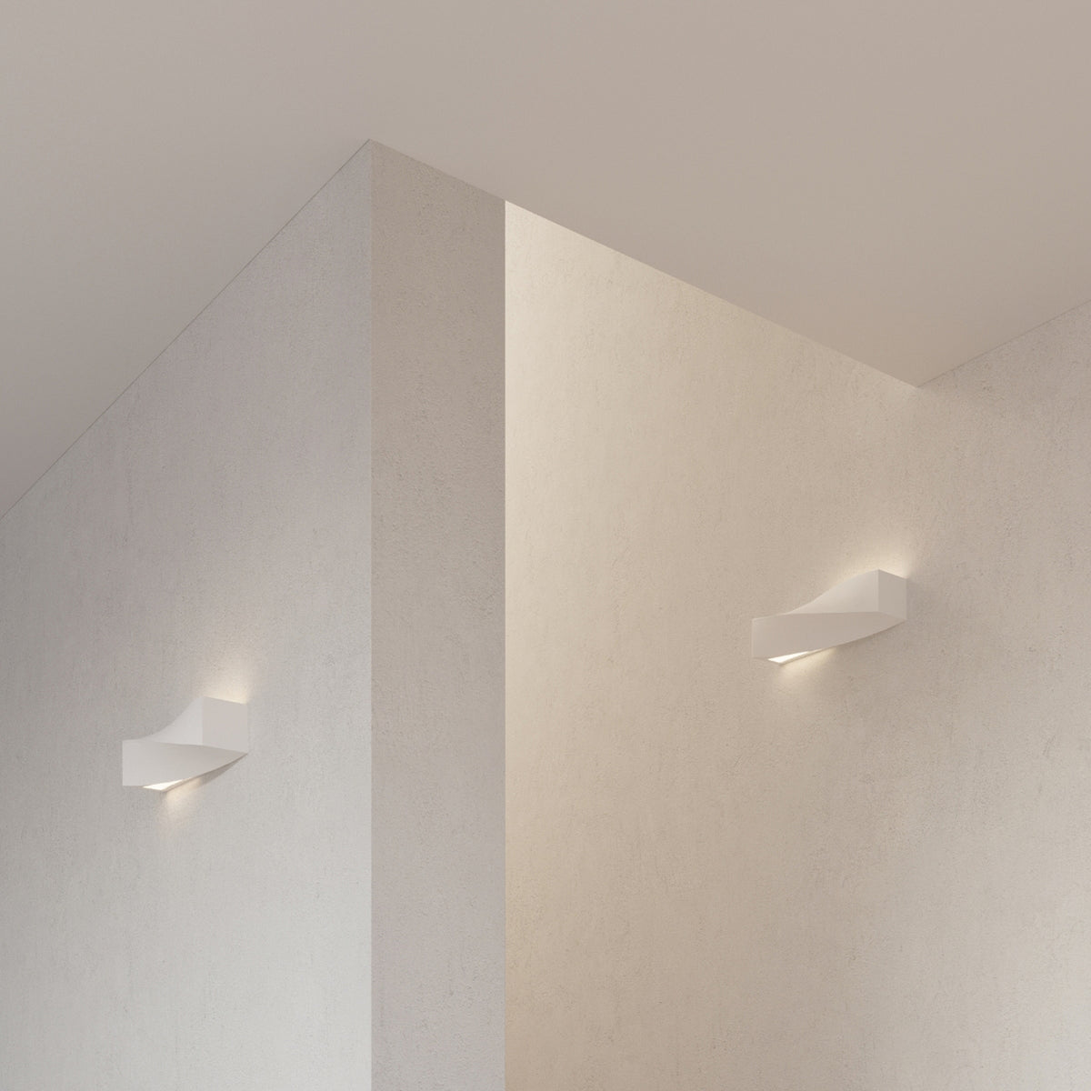 Deux appliques Sigma allumées sur les murs clairs d'un angle de pièce