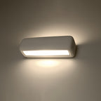 Applique Subani allumée diffusant la lumière vers le haut et vers le bas sur le mur