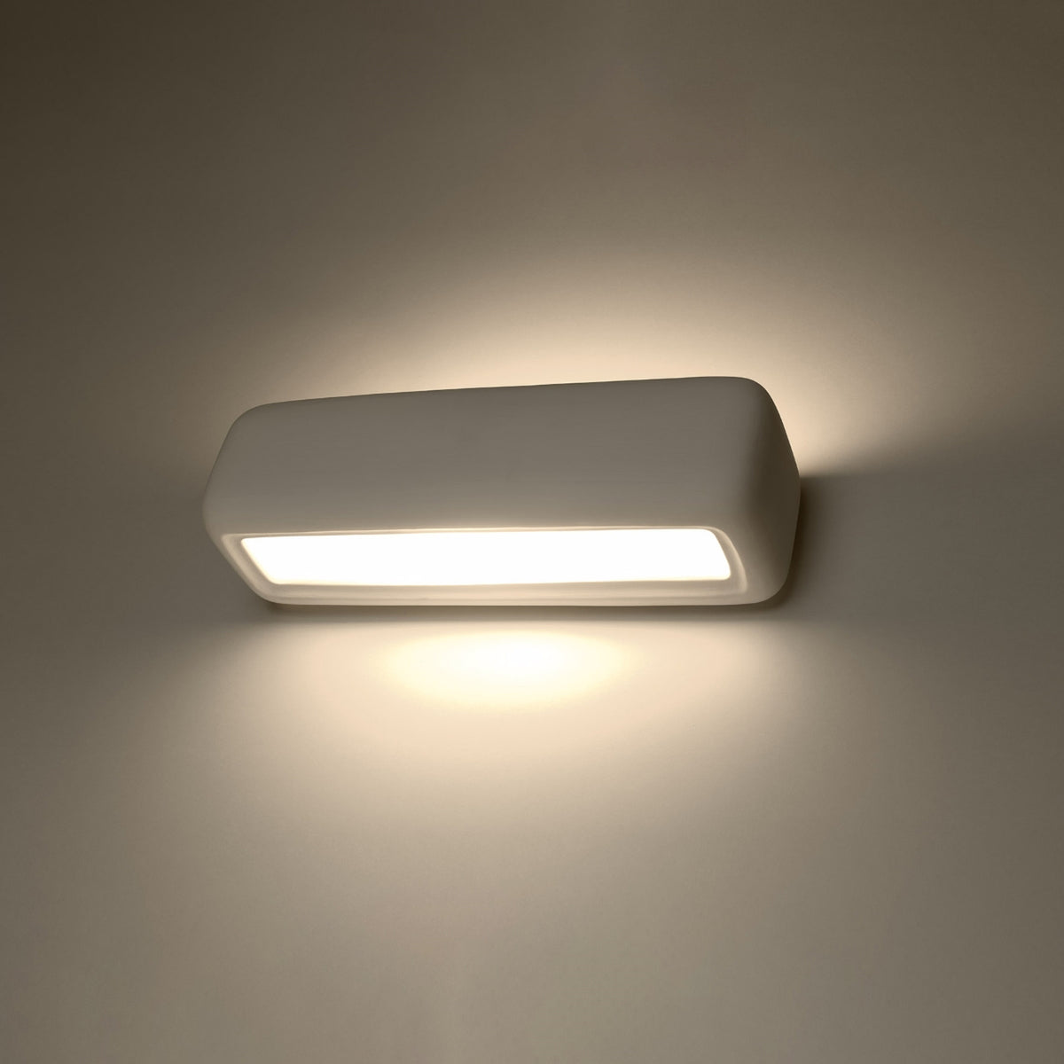 Applique Subani allumée diffusant la lumière vers le haut et vers le bas sur le mur