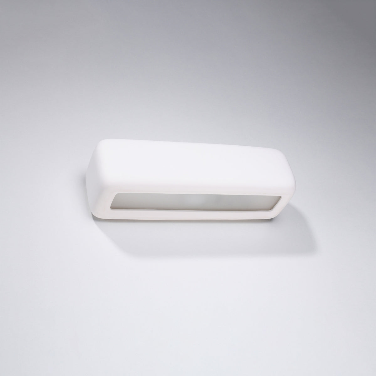 Applique Subani en céramique blanche posée sur un mur gris clair