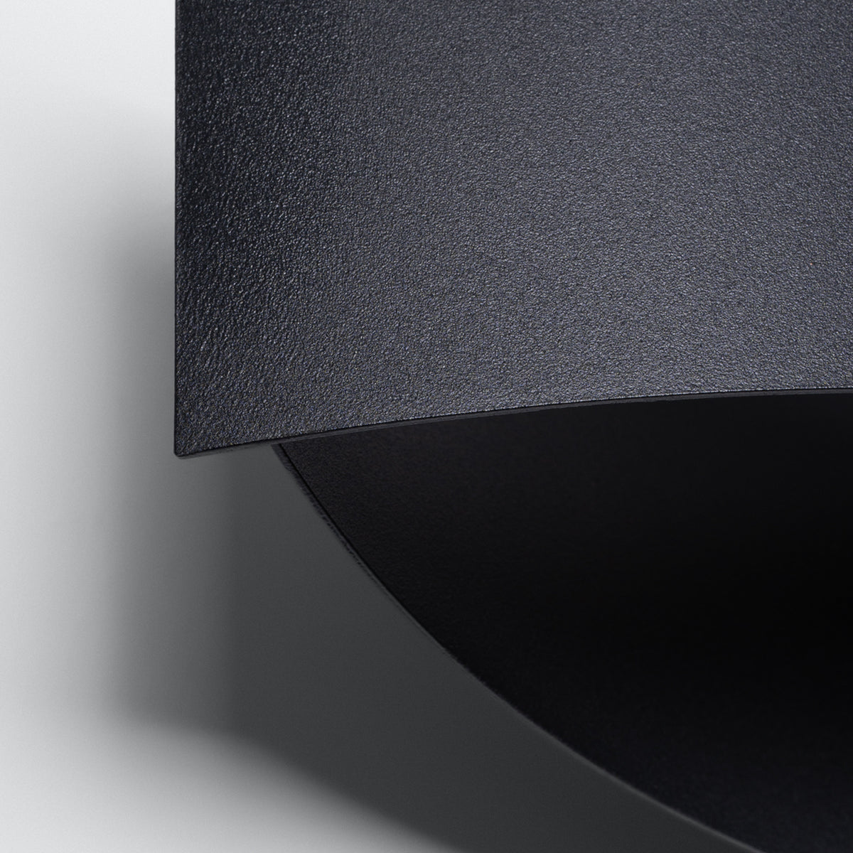 Détail du grain de l'acier et de la courbe de l'applique Toni Métal noir
