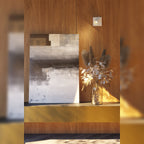 Applique murale Top I blanche fixée sur un mur en bois et éclairant un vase de fleurs séchées posé sur un buffet