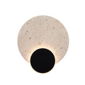 Applique murale Travertino vue de face avec son disque de travertin et son disque noir cerclé de lumière