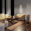 Applique murale Trend allumée sur le mur gris d'un salon au-dessus d'un canapé beige avec sa lumière vers le haut et vers le bas