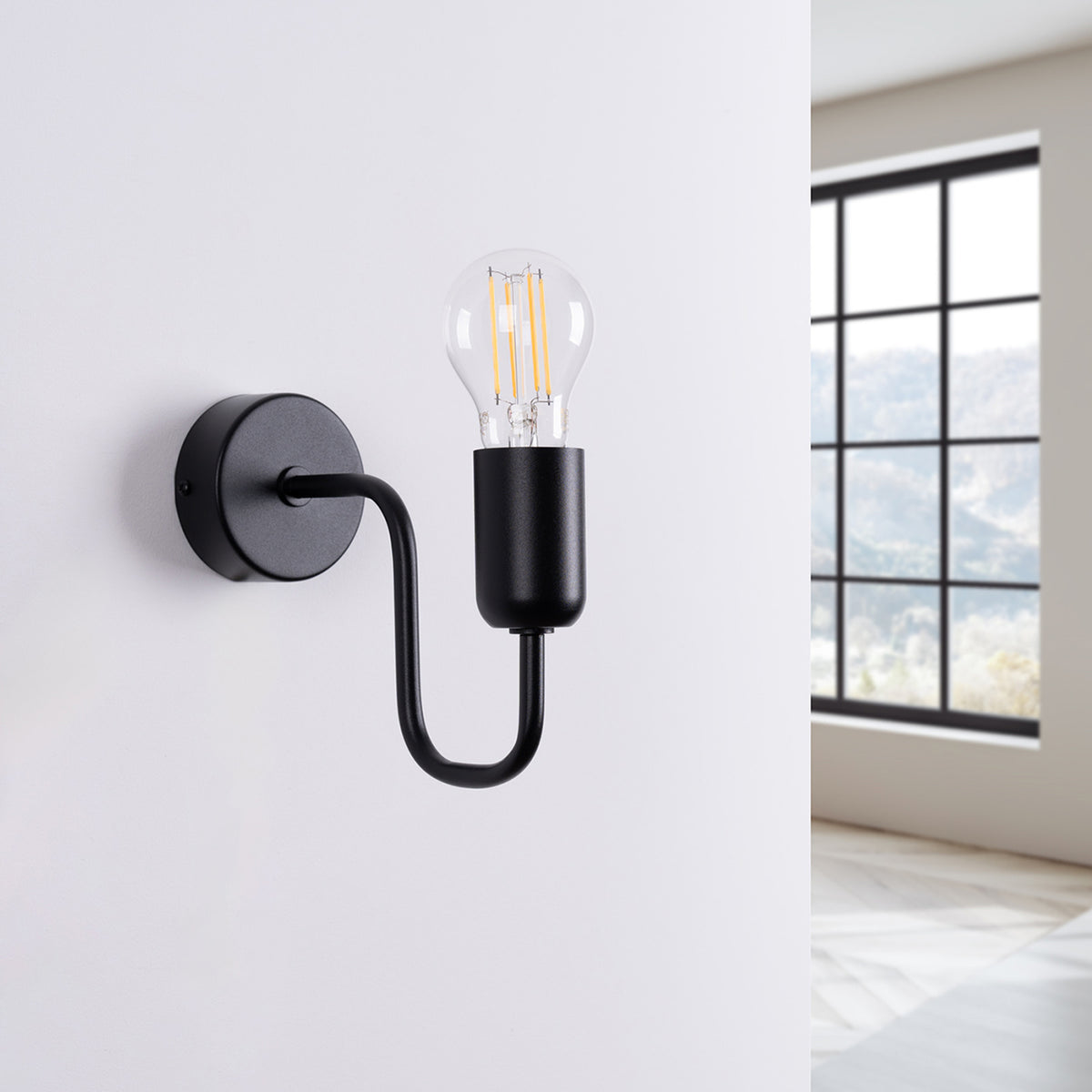 Applique Vector noire éteinte fixée sur un mur blanc près d'une fenêtre