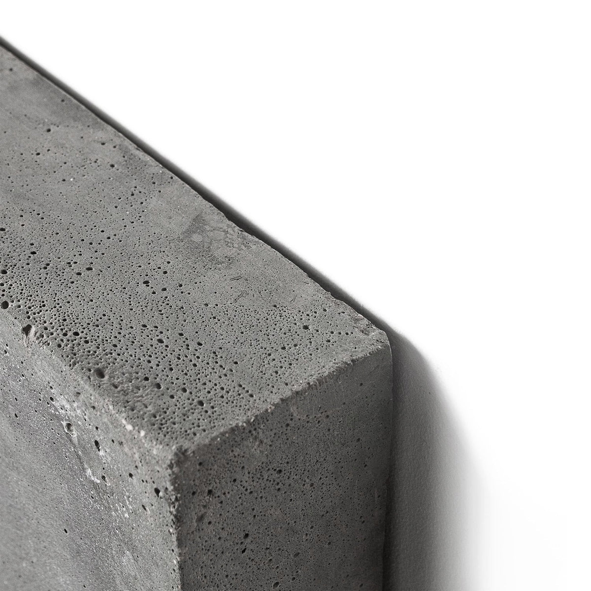 Détail d'un angle de Frag en béton brut avec son grain minéral et ses petits pores