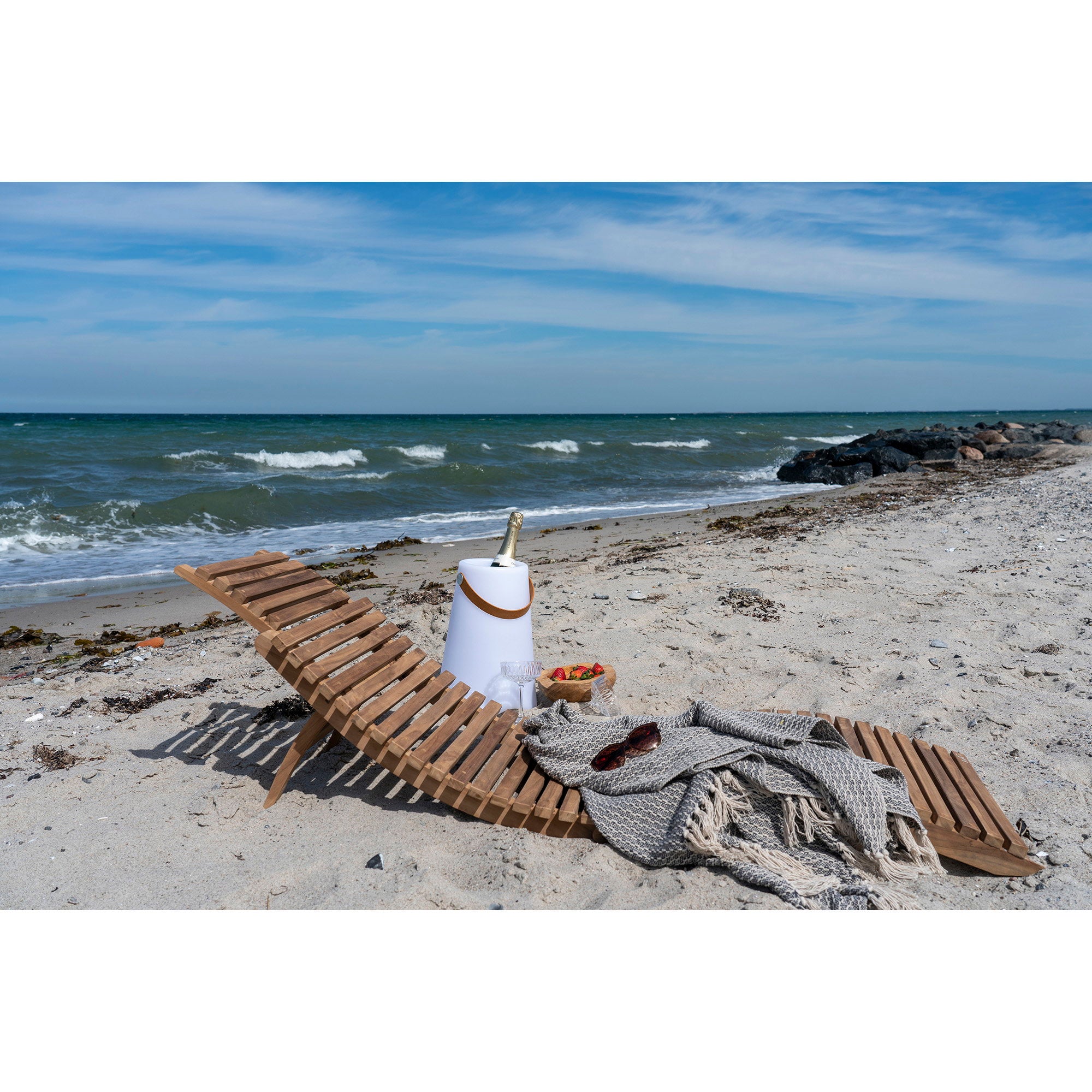 Bain de soleil Arrieta teck naturel à plat sur la plage avec champagne et plaid