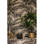 Boîte Beaded en perles noires sur une étagère entre un bougeoir singe doré et un pot de plante
