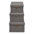 Trois boîtes de rangement Noto gris foncé empilées de la plus grande à la plus petite vues de face