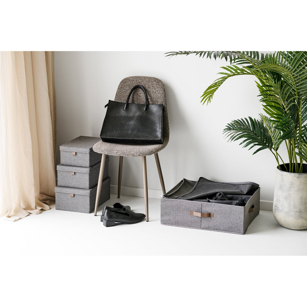Boîtes Noto grises empilées dressing avec vêtements pliés languette cuir ambiance épurée