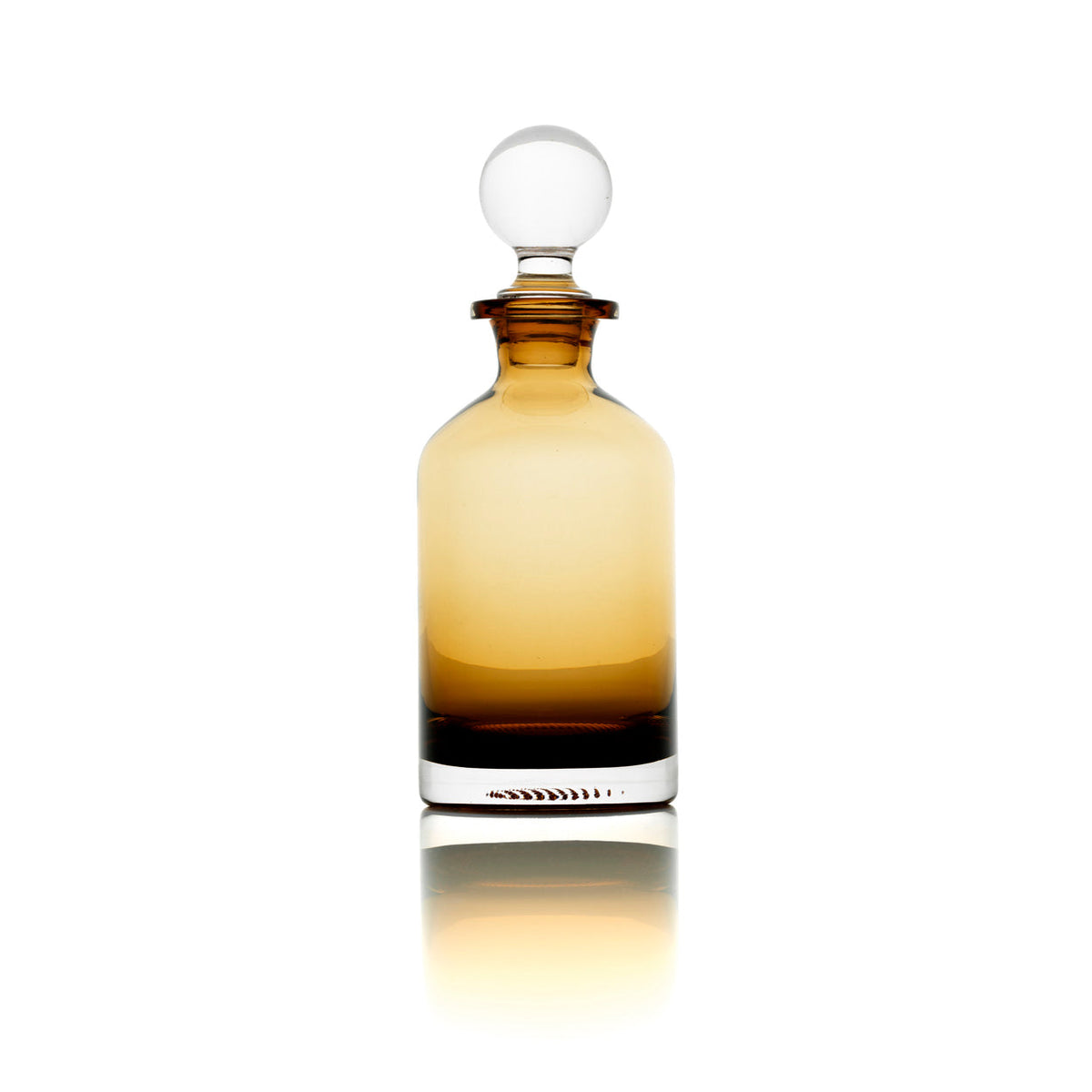 Carafe en verre ambré bouchée en contre-jour avec reflet sur fond blanc
